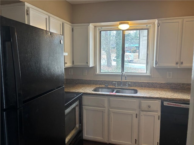 kitchen with dishwashing machine, white cabinets, black refrigerator, electric stove, and sink