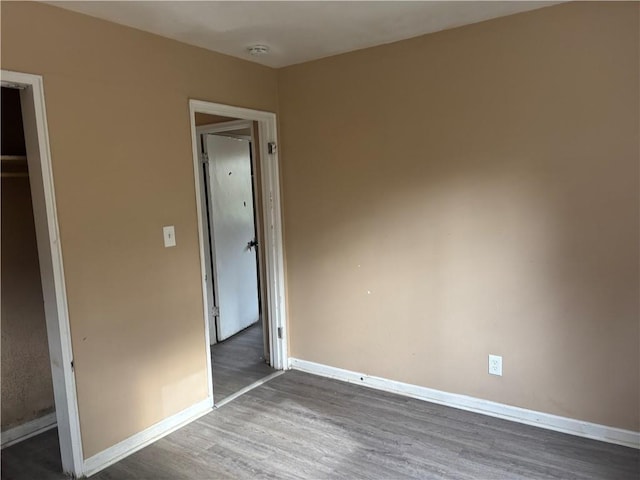 unfurnished bedroom with dark hardwood / wood-style floors and a closet