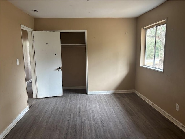 unfurnished bedroom with a closet and dark hardwood / wood-style flooring