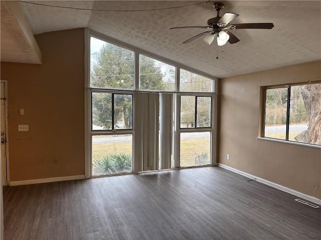 spare room with ceiling fan, dark wood-type flooring, a textured ceiling, and lofted ceiling