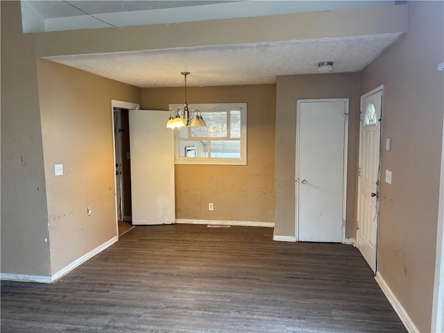 unfurnished dining area with dark hardwood / wood-style flooring and a notable chandelier