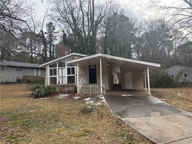 manufactured / mobile home featuring a front yard and a carport