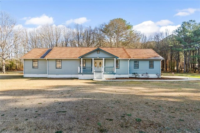 view of front facade featuring a porch, crawl space, a shingled roof, and a front yard
