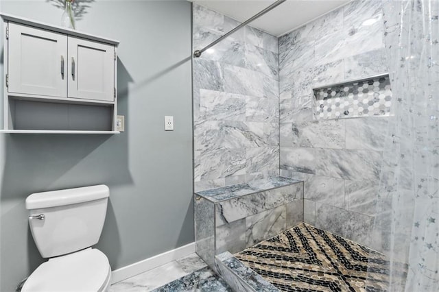 full bath with a tile shower, marble finish floor, baseboards, and toilet
