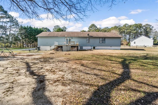 rear view of house with a lawn and a wooden deck