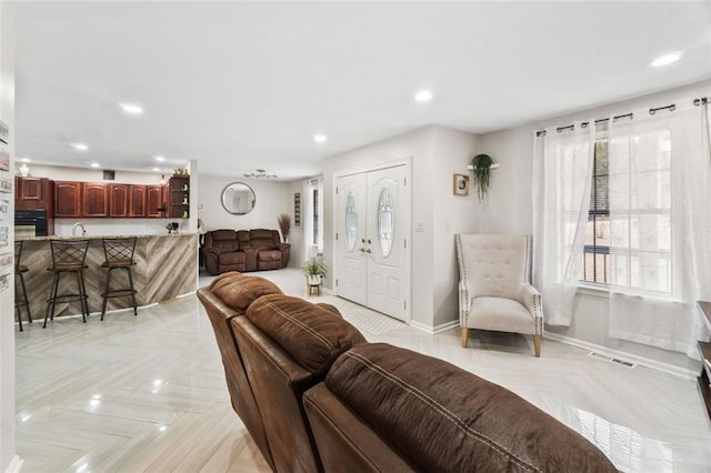 living room with recessed lighting, visible vents, and baseboards
