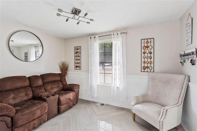 living room with a wainscoted wall and visible vents