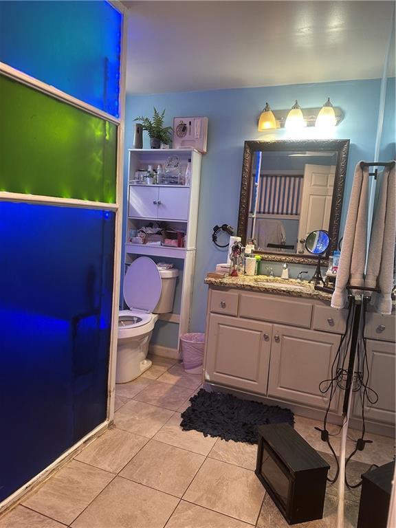 bathroom featuring toilet, tile patterned flooring, and vanity