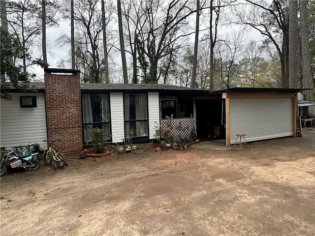 back of property featuring a garage and a chimney
