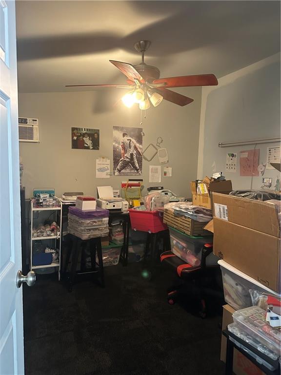 office featuring a wall unit AC and ceiling fan