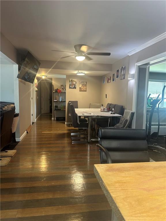 dining space featuring dark wood-style floors, baseboards, and a ceiling fan