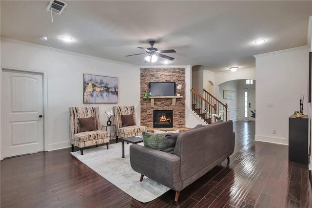 30 Lismore Way, Newnan, GA 30263 - living area with arched walkways, ceiling fan, ornamental molding, a stone fireplace, and dark wood-style flooring