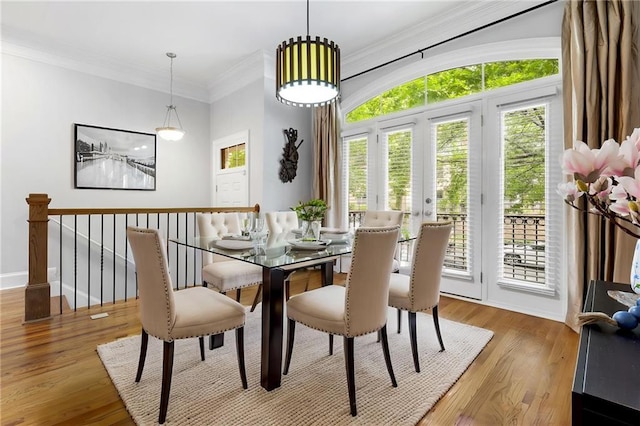 dining area with healthy amount of natural light, wood finished floors, ornamental molding, and baseboards