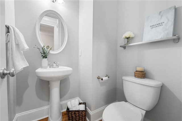 bathroom featuring toilet and baseboards