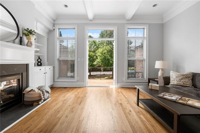 living room with beamed ceiling, light wood-type flooring, a multi sided fireplace, plenty of natural light, and ornamental molding