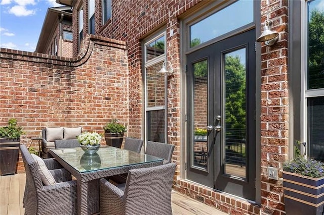 wooden deck featuring french doors and outdoor dining space