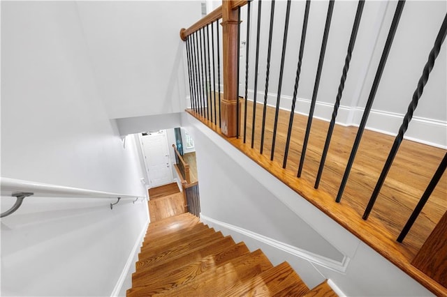 stairway with baseboards and wood finished floors