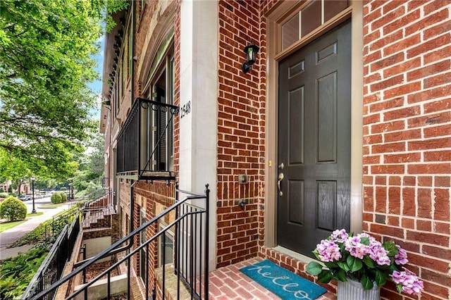 entrance to property featuring brick siding
