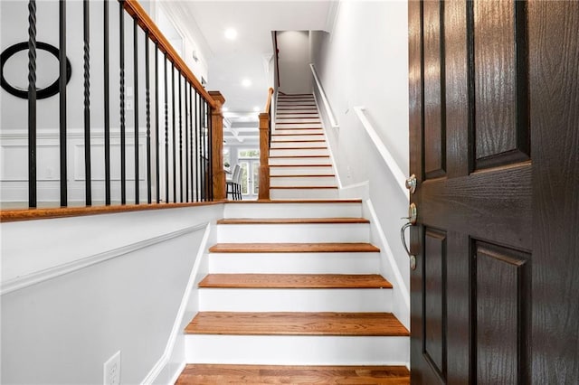 stairs with wood finished floors and recessed lighting