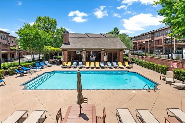 community pool with fence and a patio