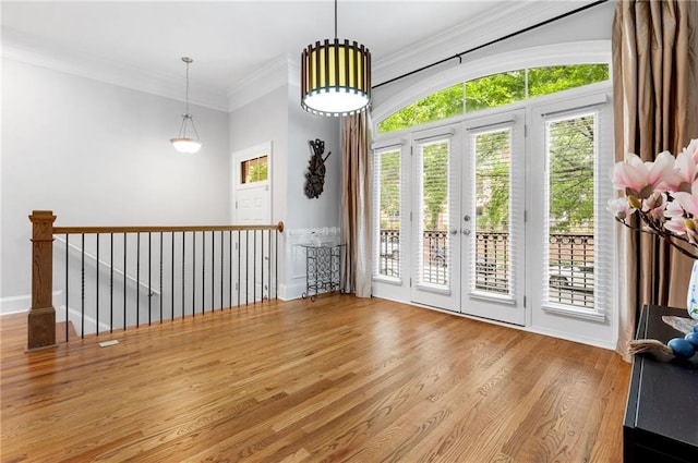 empty room featuring wood finished floors, plenty of natural light, and crown molding