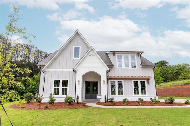 modern farmhouse style home with a front yard and french doors