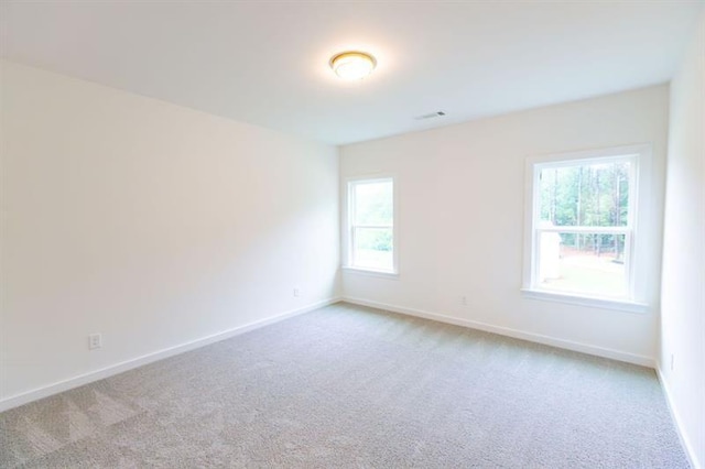 carpeted empty room featuring plenty of natural light