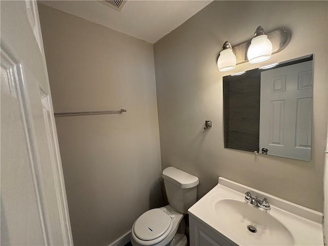 bathroom with toilet, visible vents, and vanity