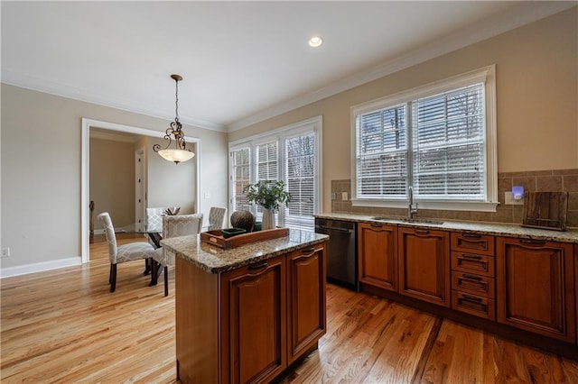 kitchen with stone counters, ornamental molding, dishwasher, and a sink