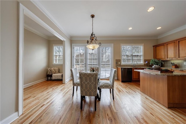 dining space with baseboards, a healthy amount of sunlight, light wood-type flooring, and ornamental molding