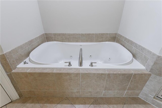 bathroom with tile patterned flooring and a jetted tub