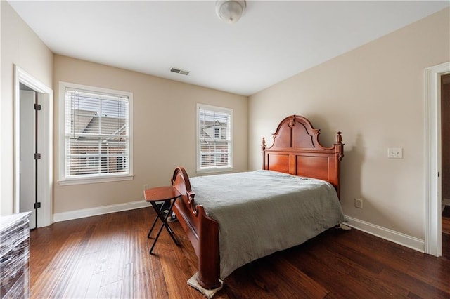 bedroom with visible vents, multiple windows, baseboards, and hardwood / wood-style flooring