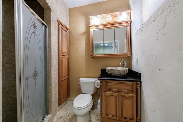 bathroom featuring vanity, toilet, and a textured wall