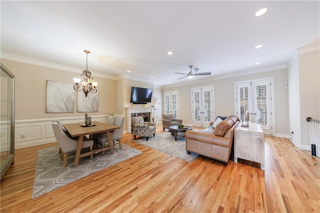 living area featuring light wood-type flooring, ornamental molding, recessed lighting, french doors, and a decorative wall