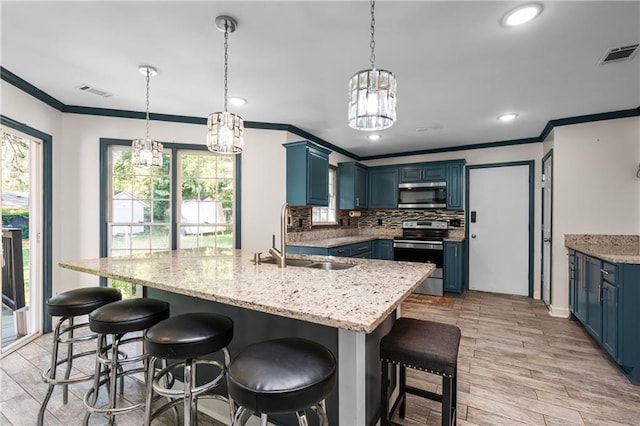 kitchen featuring stainless steel appliances, blue cabinets, light hardwood / wood-style floors, and sink