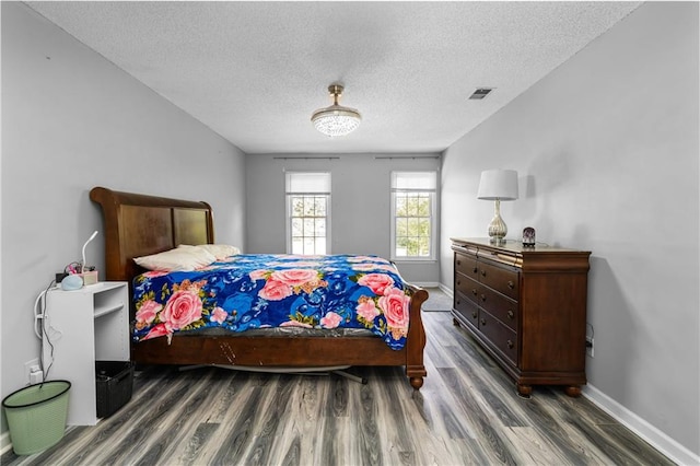 bedroom featuring a textured ceiling and dark wood-type flooring