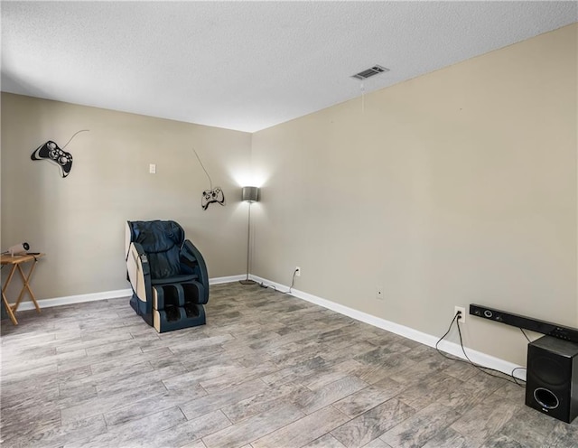 living area with a textured ceiling and hardwood / wood-style floors