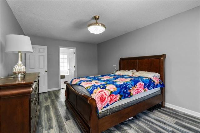 bedroom featuring a textured ceiling and dark hardwood / wood-style floors