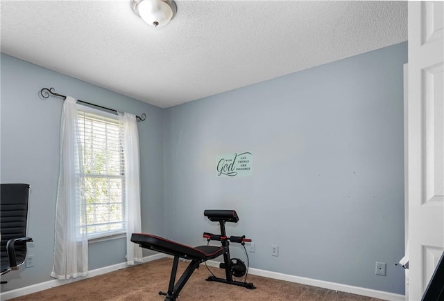 workout room featuring a textured ceiling and carpet floors