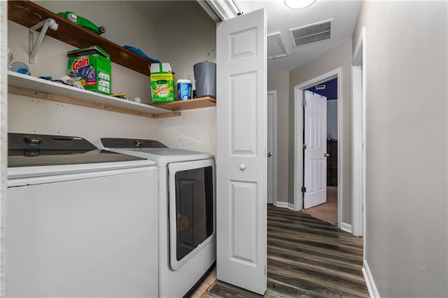 washroom with washer and clothes dryer and dark wood-type flooring