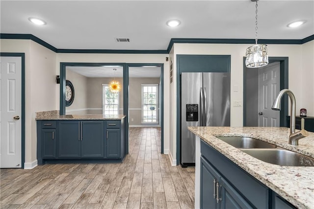 kitchen featuring blue cabinets, sink, decorative light fixtures, stainless steel fridge with ice dispenser, and light hardwood / wood-style floors