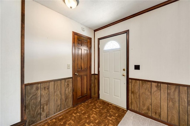 entrance foyer featuring dark parquet flooring and wood walls