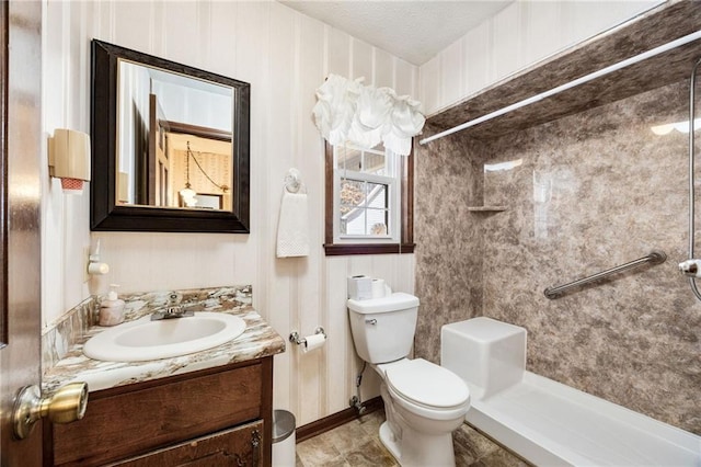 bathroom with walk in shower, vanity, toilet, and a textured ceiling