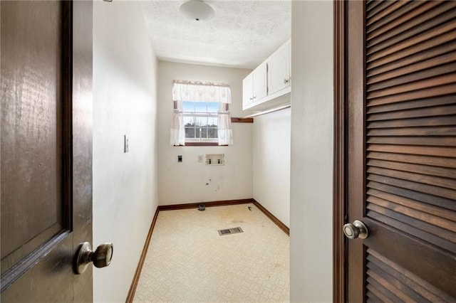 laundry area featuring cabinets, electric dryer hookup, hookup for a washing machine, and a textured ceiling