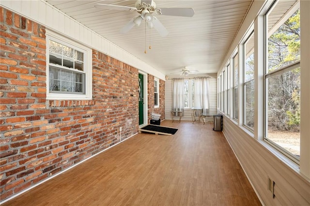 unfurnished sunroom with ceiling fan