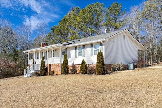 view of front of property featuring a porch, central AC unit, and a front lawn