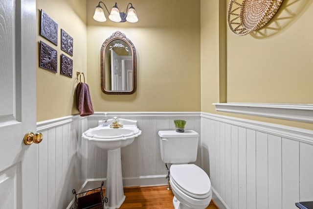 bathroom with hardwood / wood-style floors, radiator heating unit, and toilet