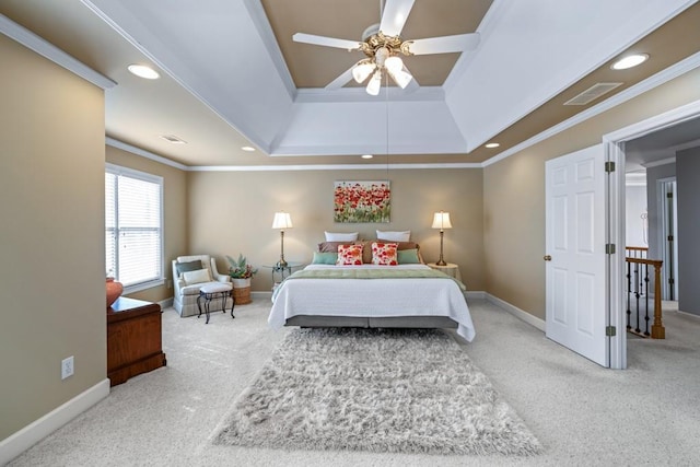 carpeted bedroom with crown molding, a tray ceiling, and ceiling fan