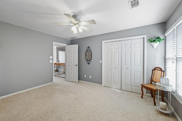 bedroom with light carpet, ceiling fan, and a closet