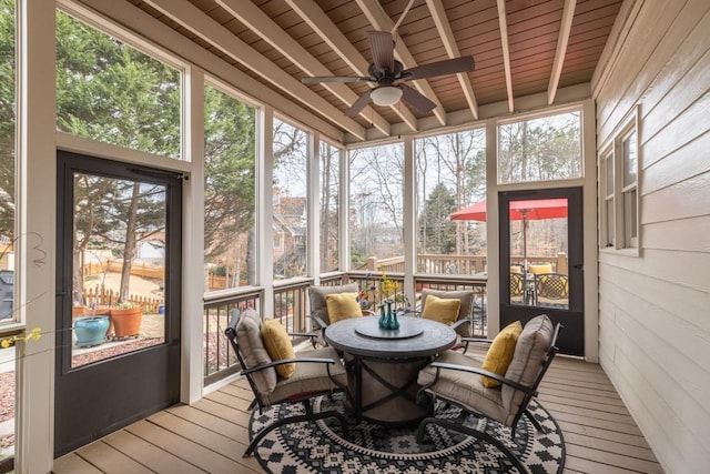 sunroom featuring ceiling fan, a healthy amount of sunlight, wooden ceiling, and beam ceiling